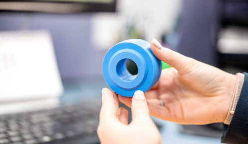 A hand holding a CNC machined plastic component