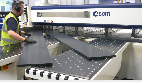 A CNC beam saw operator at Oadby Plastics placing some plastic onto the machine