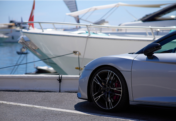 A sports car and yacht docked showcasing plastic parts used by the automotive and marine industry