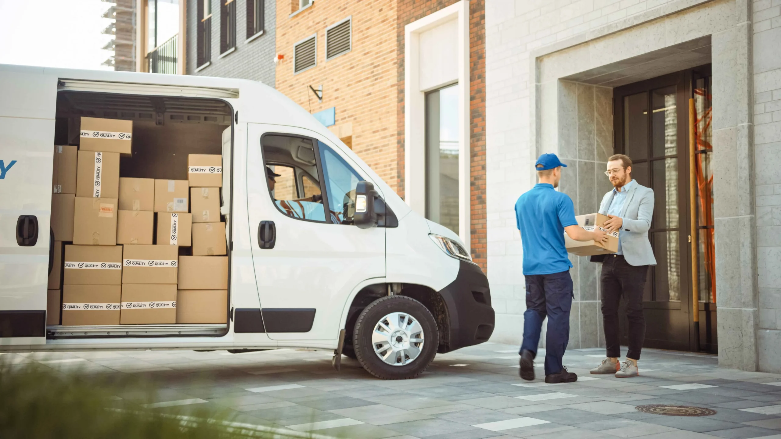 An Oadby Plastics carrier van and delivery man handing over parcels to a customer