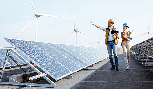 Sustainably conscious companies using a row of solar panels, inspired by those used on the roof of Oadby Plastics head office in Leicester, with wind farm turbines in the background