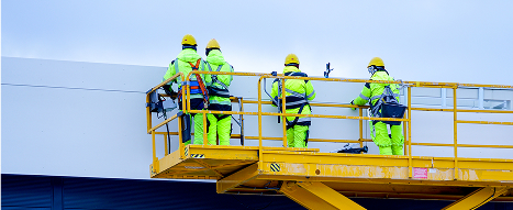 Scissor lift using engineering plastic components with work men in high-vis outfits