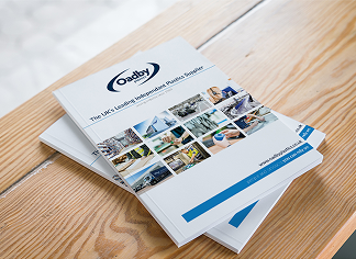 A stack of Oadby Plastics corporate brochures on a table