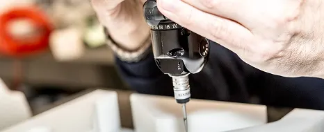 Close-up of a QA machine and piece of engineered plastic component at Oadby Plastics