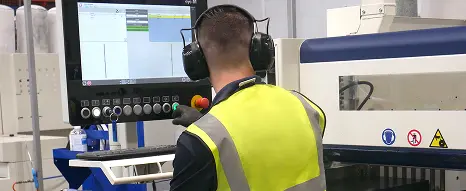 An operator at a CNC beam saw machine at Oadby Plastics