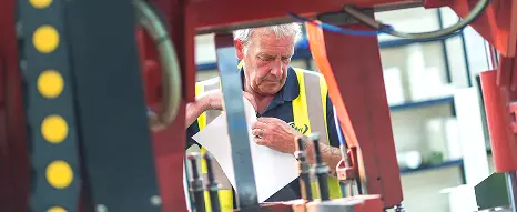 Close-up of a machine operator at a billeting machine at Oadby Plastics