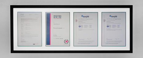 A wall of frames with ISO and industry certifications named to Oadby Plastics