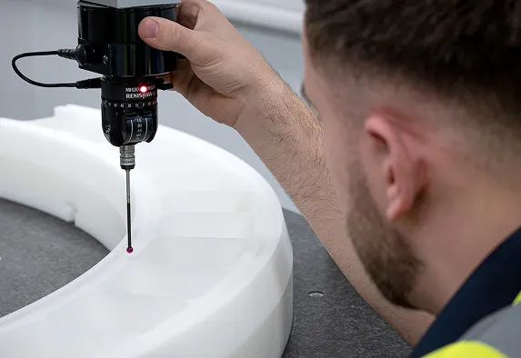 A close up image of an Oadby Plastics technical team member using a QA instrument to check the product against its CNC machining specifications