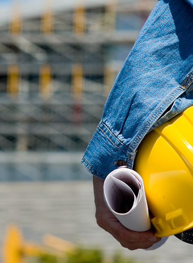 A portrait image of a workman with his hard hat and building plans under his arm, including specified engineering plastics