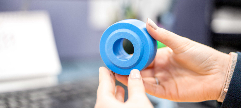 A hand holding a precisely CNC machined plastic component helping customers to choose the right material for their project