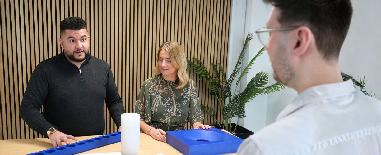 Business Development Team meeting at Oadby Plastics at a meeting table with precision engineered plastic parts on the table