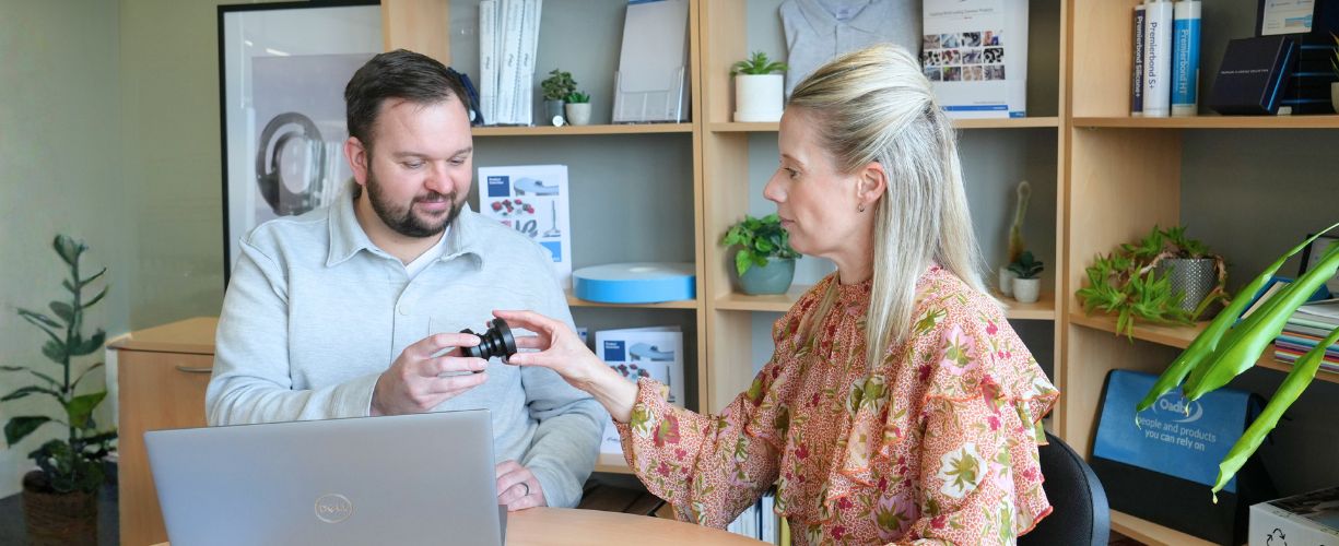 Business Development Team meeting at Oadby Plastics at a meeting table with precision engineered plastic parts on the table